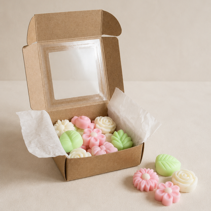 Caja kraft con wax melts explosión floral junto a piezas sueltas sobre fondo neutro