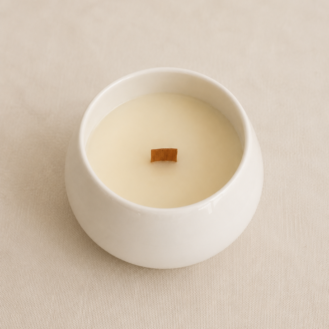 Vista superior de vela aromática de soja en cuenco de porcelana blanca
