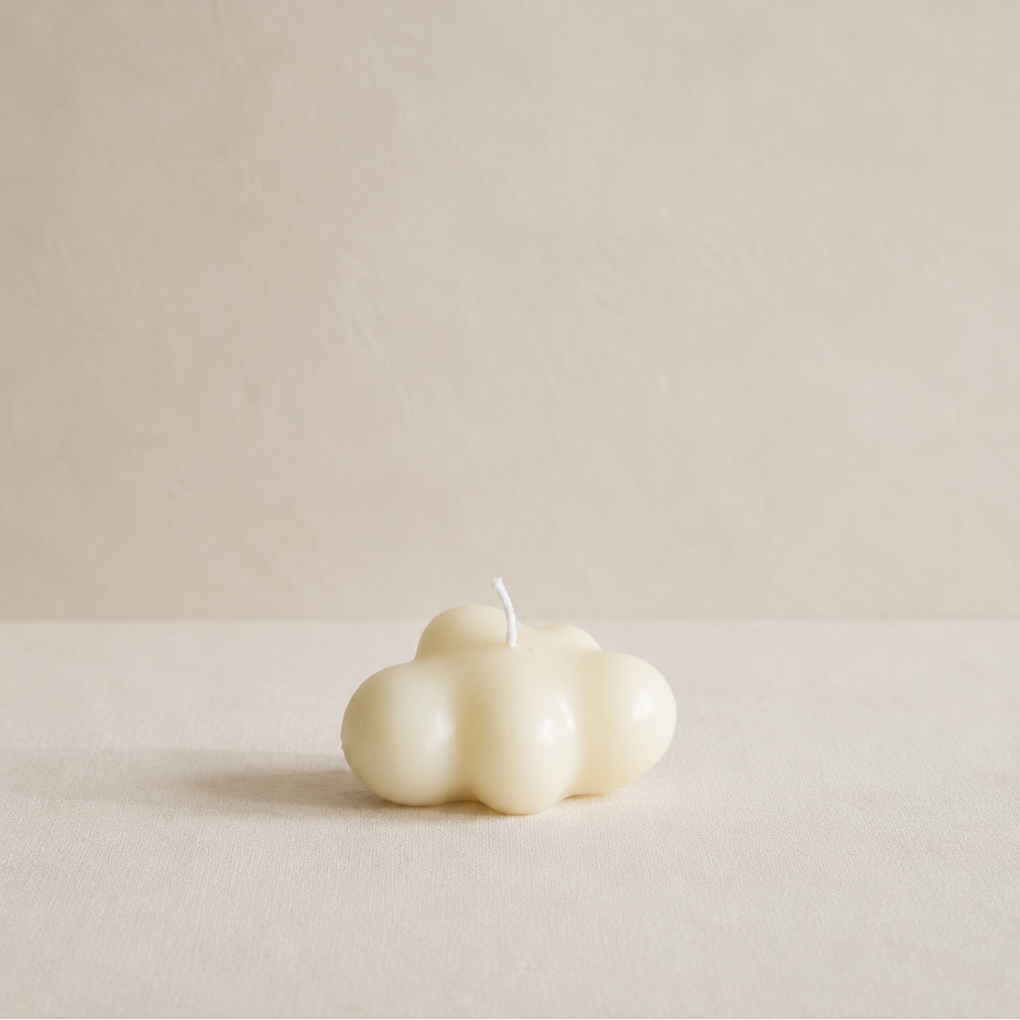 Vela decorativa nube pequeña de cera de soja sobre plato beige