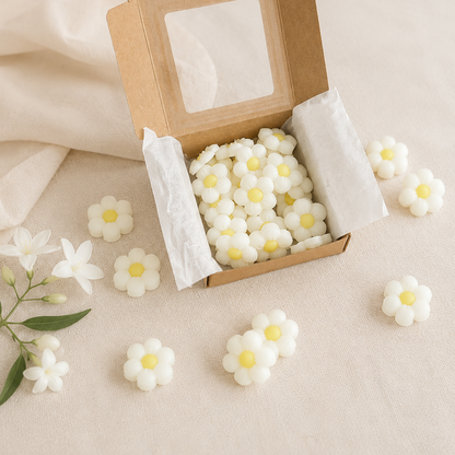 Caja kraft con wax melts flores de jazmín junto a flores sueltas sobre fondo neutro