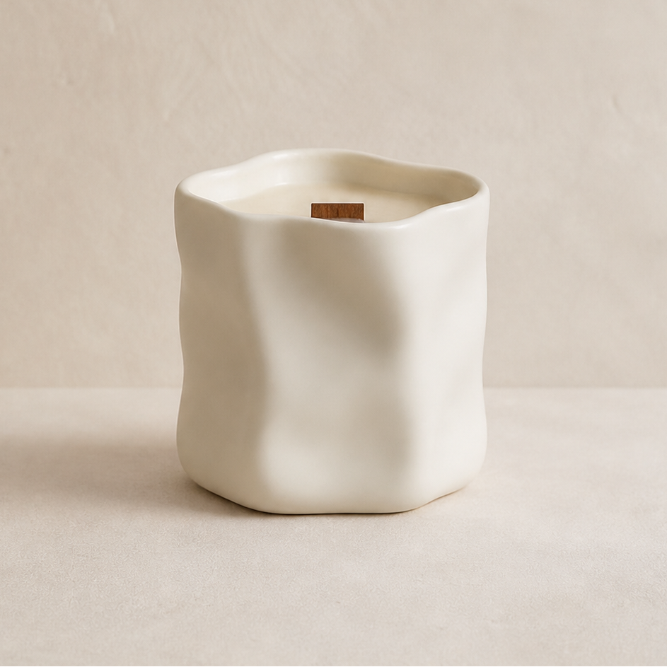 Vela aromática de soja en cerámica blanca irregular en composición minimalista